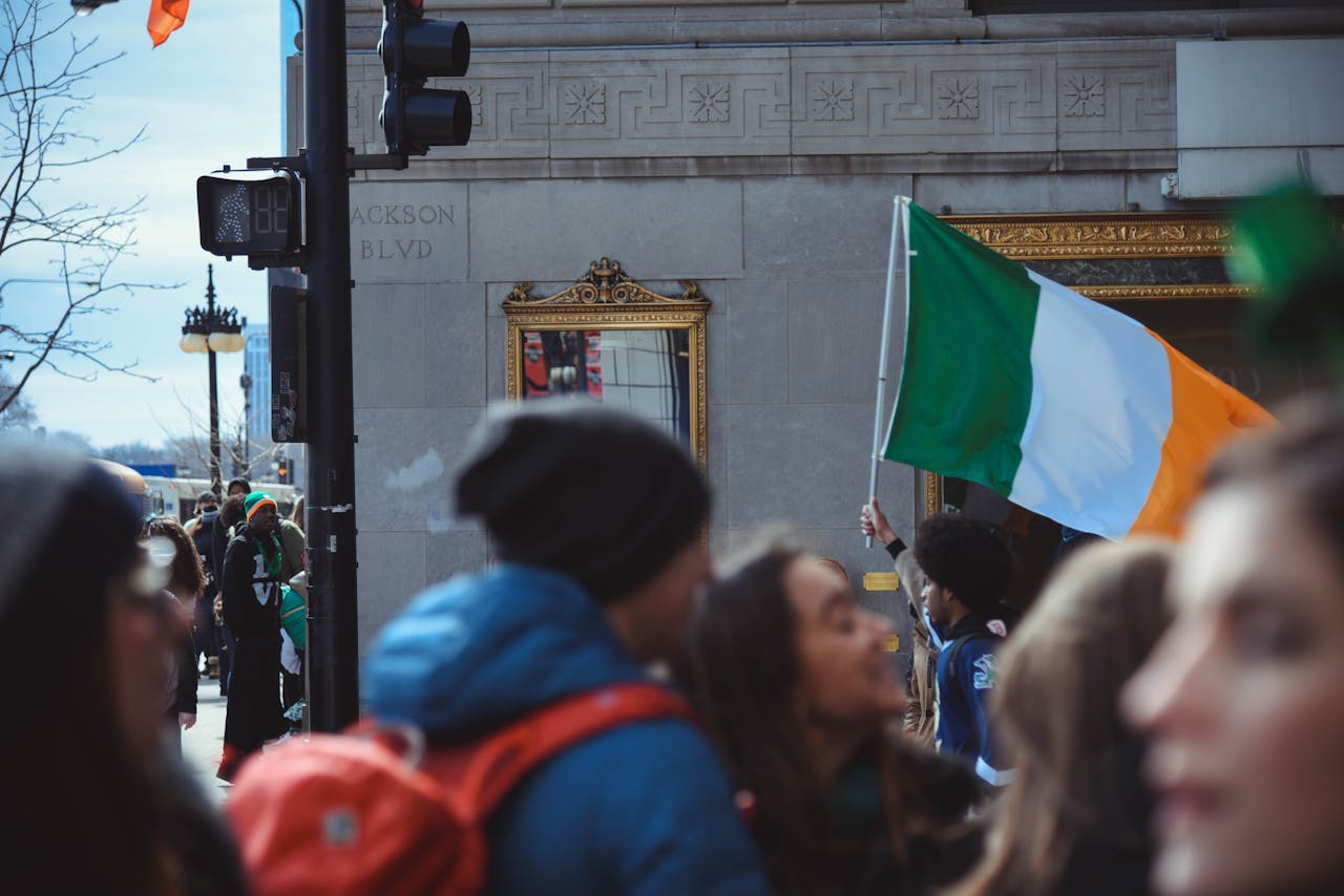 Crowd celebrates St. Patricks Day in Chicago with Irish flags and festive atmosphere.